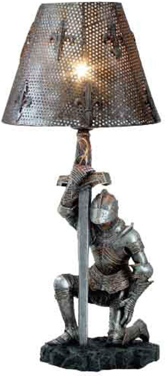 Kneeling knight sword table lamp lit, with dotted light through the fleur-de-lis shade
