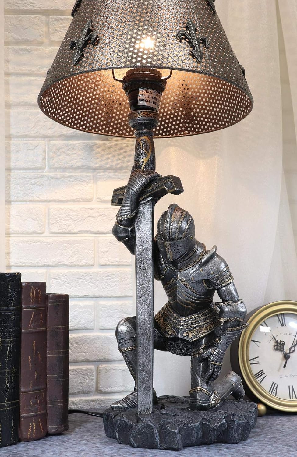 Kneeling knight table lamp glowing beside old books on a shelf