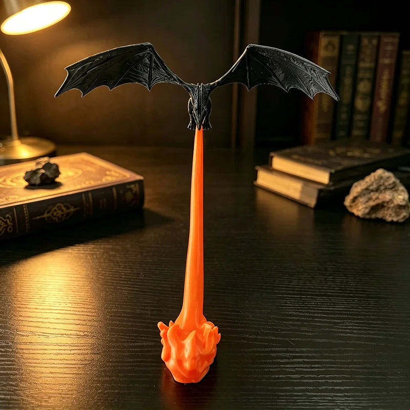 Front view of the black dragon with wings spread above its orange fire breath