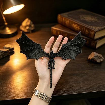 Black dragon figure held in an open hand to show size