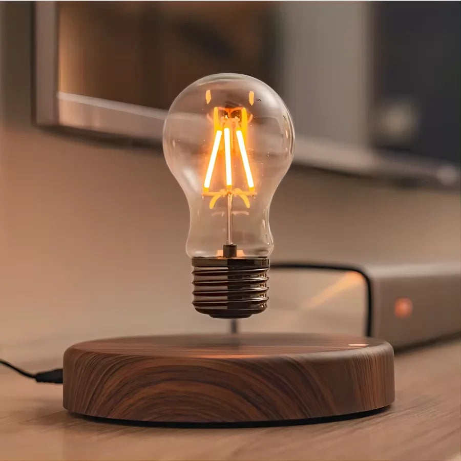 Floating filament bulb hovering over its round walnut look base on a desk