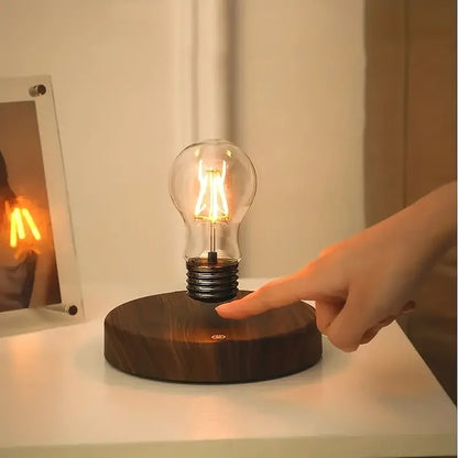 Finger tapping the touch switch on the base of the levitating bulb lamp