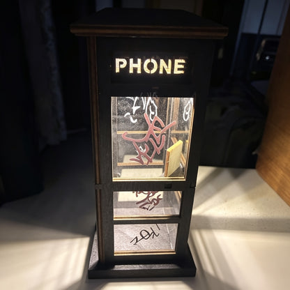 Graffiti phone booth lamp lit, close up